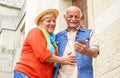 Cheerful senior couple having fun with new smart phone social trends - Happy old people using mobile device outdoor - Concept of Royalty Free Stock Photo