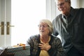 Cheerful senior couple receiving a gift box