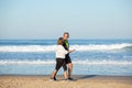 Cheerful senior couple talking while walking along shore Royalty Free Stock Photo