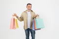 Cheerful senior man holding colorful shopping bags in two hands Royalty Free Stock Photo