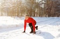 Cheerful senior man ready to run on snowy country road on cold winter day, full length. Active lifestyle concept Royalty Free Stock Photo