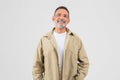 Cheerful senior man smiling at camera on white background