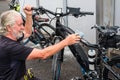 Cheerful senior man with white hair and beard washes his bicycle at the service station. High pressure pomp. One people working