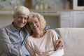 Cheerful senior older couple hugging at home, sitting on sofa Royalty Free Stock Photo