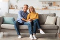 Cheerful Senior Spouses Holding Hands Hugging Sitting On Sofa Indoor Royalty Free Stock Photo