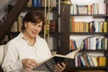 Cheerful senior woman sitting and reading a book Royalty Free Stock Photo