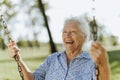 Cheerful senior woman on a swing at a playground Royalty Free Stock Photo
