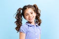 Portrait of winsome little girl,school age kid in summer dress isolated over blue background. Concept of children Royalty Free Stock Photo