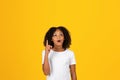 Cheerful shocked adolescent curly african american girl in white t-shirt show finger up, got idea