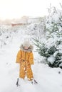 A cheerful, sincerely laughing child throws snow.