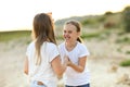 Cheerful sisters on sandy shore Royalty Free Stock Photo