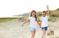 Cheerful sisters on sandy shore Royalty Free Stock Photo