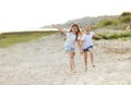 Cheerful sisters on sandy shore Royalty Free Stock Photo