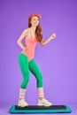 Cheerful slim girl doing shaping workout using step platform