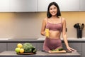 Cheerful Slim Japanese Woman Drinking Juice Cooking Dinner In Kitchen Royalty Free Stock Photo