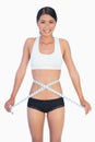 Cheerful slim woman measuring her waist
