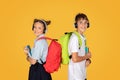 Cheerful smart caucasian teenager girl and boy schoolchildren with books, backpacks in wireless headphones Royalty Free Stock Photo