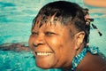 Cheerful smiling African American woman swimming in the pool on a sunny day Royalty Free Stock Photo