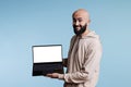 Cheerful arab man advertising laptop