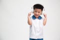 Cheerful smiling asian little boy in student uniform listening music with headphone isolated on white background. Royalty Free Stock Photo