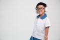 Cheerful smiling asian little boy in student uniform listening music with headphone isolated on white background. Royalty Free Stock Photo