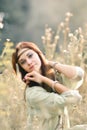 Attractive,charming,exquisite,lovely,red-haired girl in sunny summer field