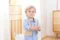 A cheerful and smiling boy holds a figure in his hands. Child in kindergarten. Portrait of fashionable male child. Smiling boy pos