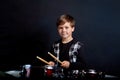 A cheerful smiling child looks at the camera and plays the drums. Boys Studios. Royalty Free Stock Photo