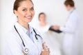 Cheerful smiling female doctor on the background with doctor and his patient in the bed. High level and quality of Royalty Free Stock Photo