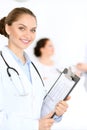 Cheerful smiling female doctor on the background with physician and his patient in the bed Royalty Free Stock Photo