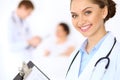 Cheerful smiling female doctor on the background with physician and his patient in the bed Royalty Free Stock Photo