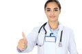 Cheerful smiling female doctor showing thumbs up, isolated over white background. Latin american or Hispanic young woman Royalty Free Stock Photo