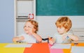 Cheerful smiling little boy and cute little girl having fun against blackboard, school concept. First time to school Royalty Free Stock Photo