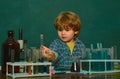 Cheerful smiling little boy having fun against blue wall. Back to school. First grade. Biology experiments with Royalty Free Stock Photo