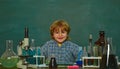 Cheerful smiling little boy having fun against blue wall. They carried out a new experiment in chemistry. Preschooler Royalty Free Stock Photo