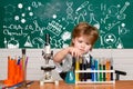 Cheerful smiling little boy having fun against blue wall. First grade. Science and education concept. My chemistry Royalty Free Stock Photo