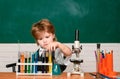 Cheerful smiling little boy having fun against blue wall. First grade. Science and education concept. My chemistry Royalty Free Stock Photo