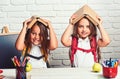 Cheerful smiling little girls with books on head. Looking at camera. School concept. Back to School. Royalty Free Stock Photo