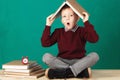 Cheerful smiling little school boy with big heavy books on his h Royalty Free Stock Photo