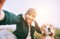 Cheerful smiling Man takes selfie photo with his best friend beagle dog during walking. Human and pets concept image Royalty Free Stock Photo