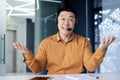 Cheerful and smiling online customer support tech worker, Asian man with call headset smiling and looking at webcam Royalty Free Stock Photo