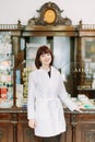 Cheerful smiling pharmacist woman standing in pharmacy drugstore Royalty Free Stock Photo