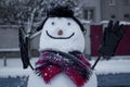 Cheerful smiling snowman sitting on the bench.