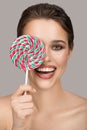 Cheerful smiling woman with big colorful lollipop. Royalty Free Stock Photo