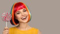 smiling woman with bright colorful hair holding big lollipop Royalty Free Stock Photo