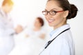 Cheerful smiling woman-doctor on the background of his patient in the bed. Medicine concept Royalty Free Stock Photo