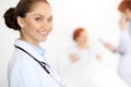 Cheerful smiling woman-doctor on the background of his patient in the bed. Medicine concept Royalty Free Stock Photo