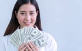 Cheerful smiling woman holding money dollars in her hand looking at camera on white background Royalty Free Stock Photo