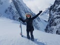 Cheerful snowboarder outstretches her arms before riding down untouched hill.