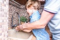 Cheerful son and his father washing hands together with soap and water in bathroom. Man and little Boy Stay safety at Royalty Free Stock Photo